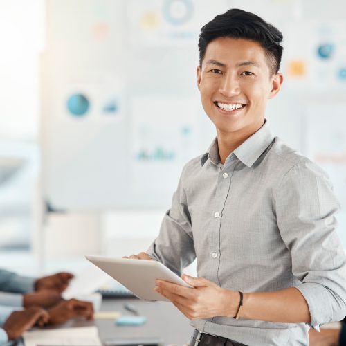 Workshop, portrait and businessman with a tablet in a meeting for planning, strategy and collaboration at work. Smile, digital and corporate Asian worker typing on technology during a seminar.